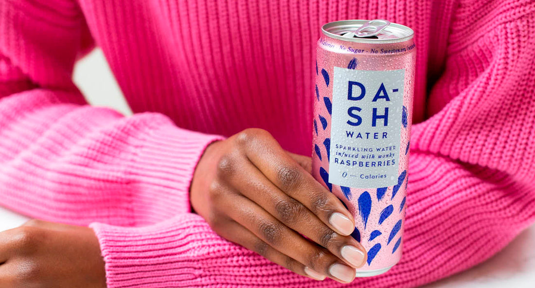person in pink jumper holding can of DASH