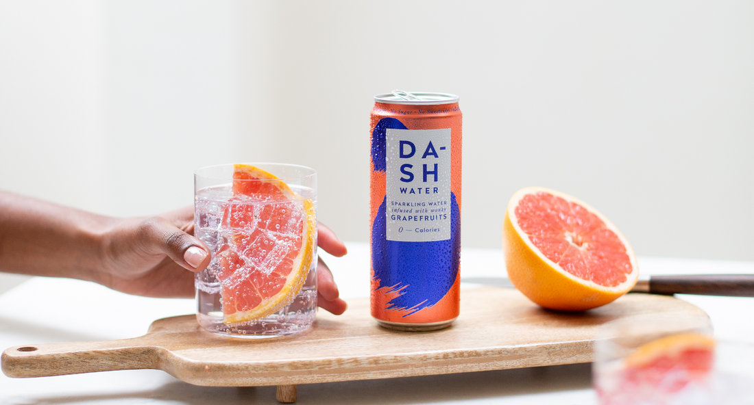 Glass and can of DASH grapefruit sparkling water with grapefruit wedge